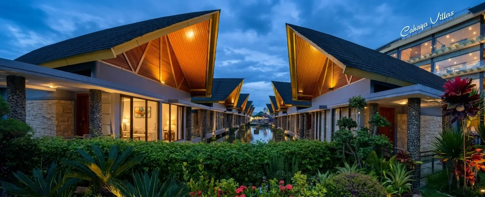 Cahaya Villa Garut - traditional villas with peaked roofs reflected in a still pond at dusk